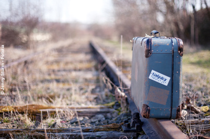 Koffer auf einem Bahngleis: Reisedurchfall kann den Urlaub verderben. Vorbeugung auf Reisen und was im Ernstfall zu tun ist.